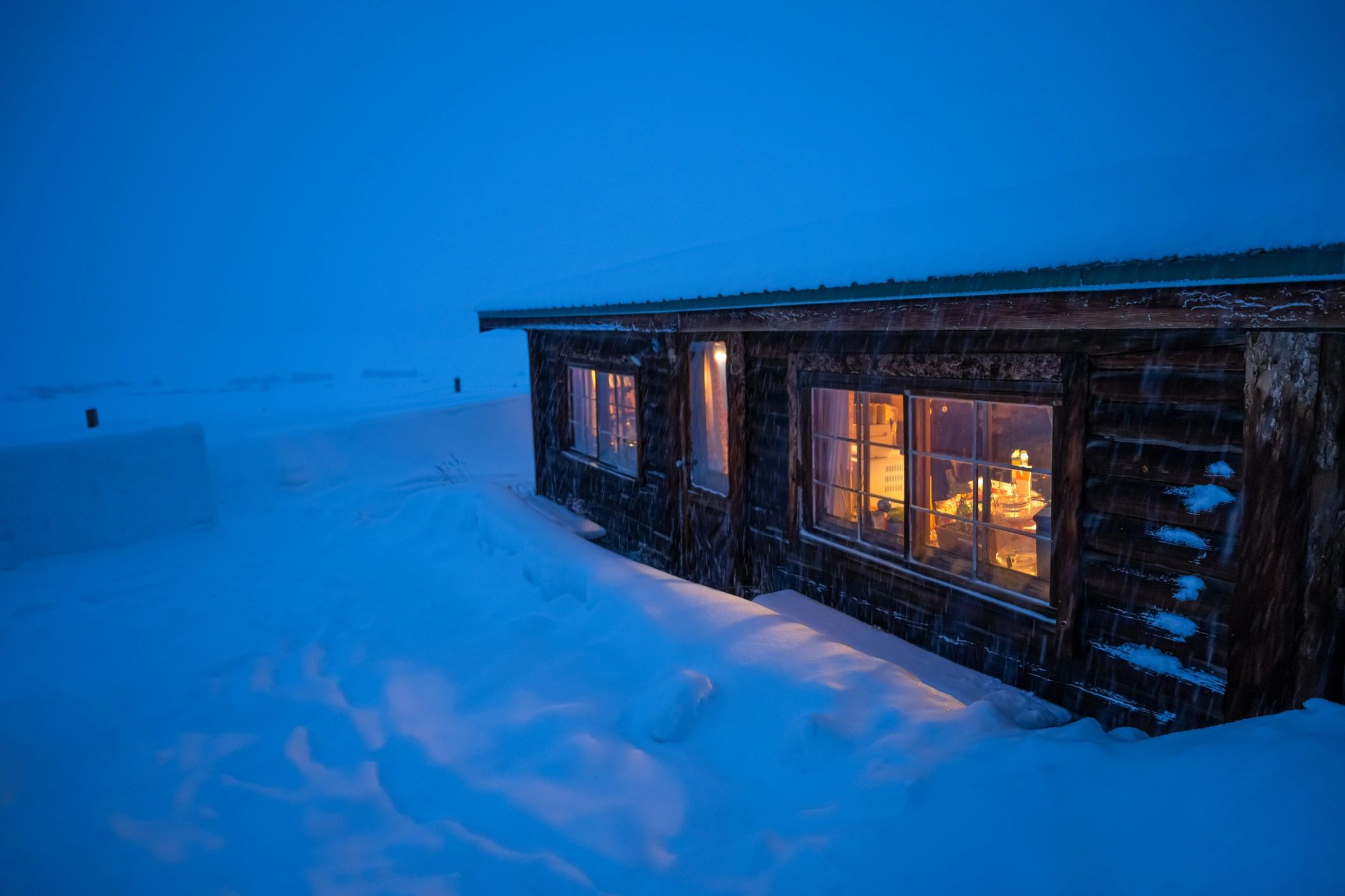 Cozy log cabin on a snowy evening in Alaska